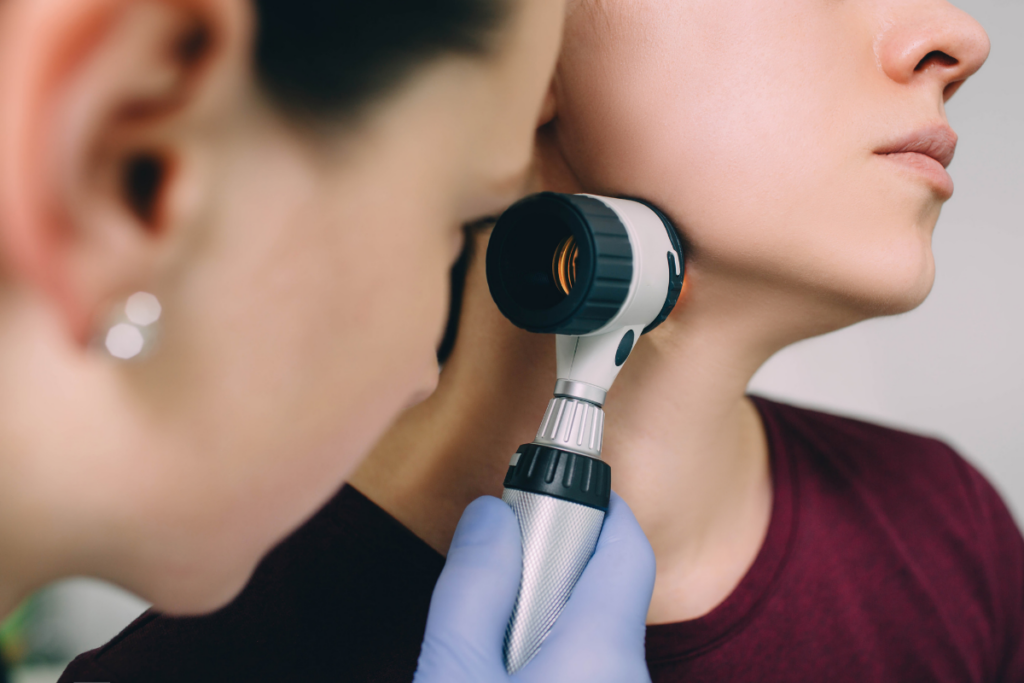 Dermatologist looking at possible skin tag with dermatoscope