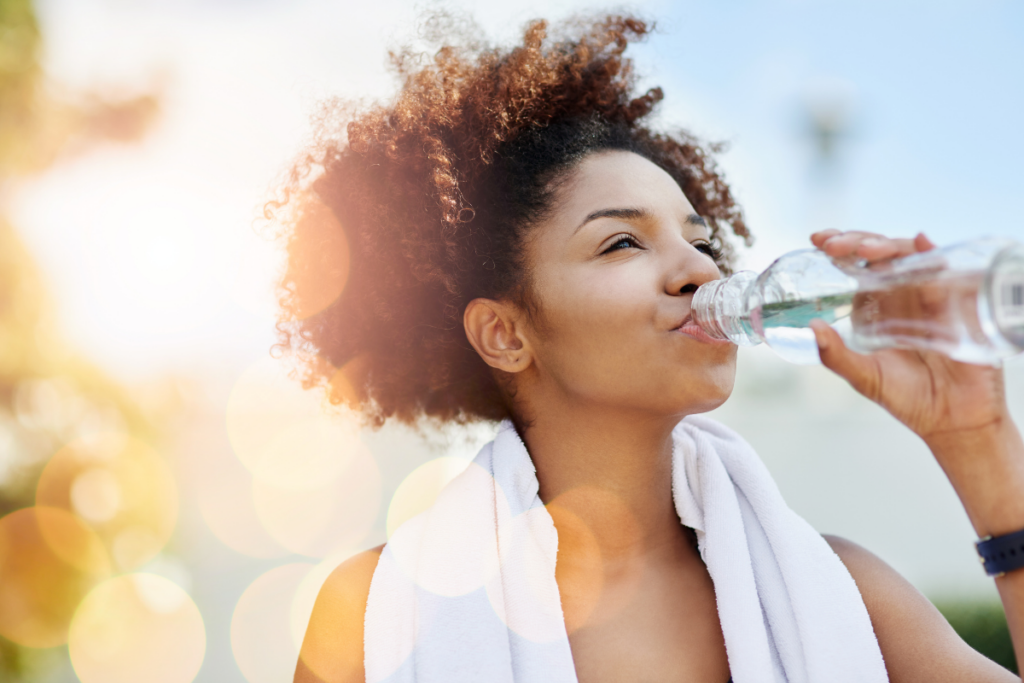 Woman drinking water and enjoying no-makeup skin outside