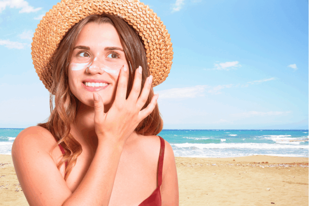 Woman putting sunscreen on her face at the beach