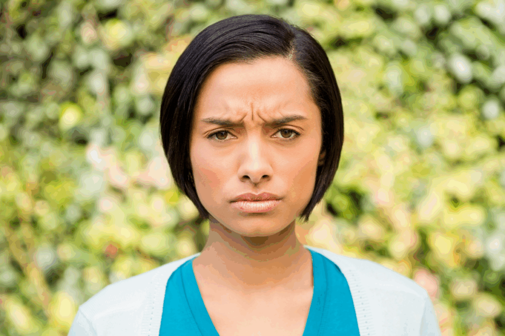 Young woman frowning and causing wrinkles on her forehead