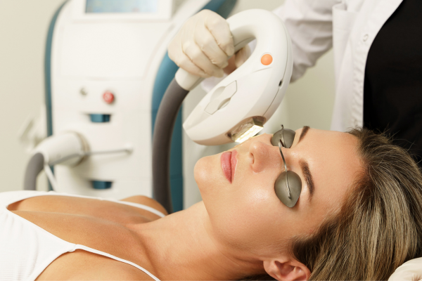 Woman receiving IPL treatment on her face in MedSpa