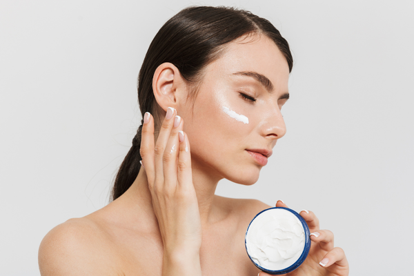 Young woman with moisturizer on her face as part of her aftercare for non-invasive skin treatments