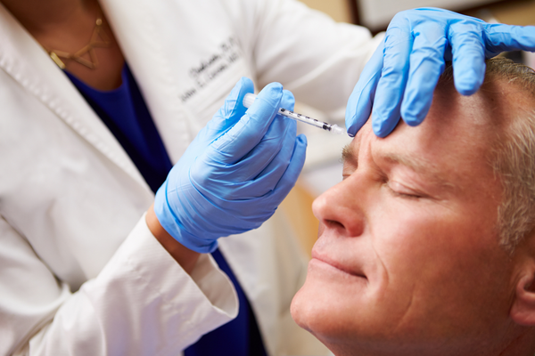 Man receiving Botox treatment on glabellar lines