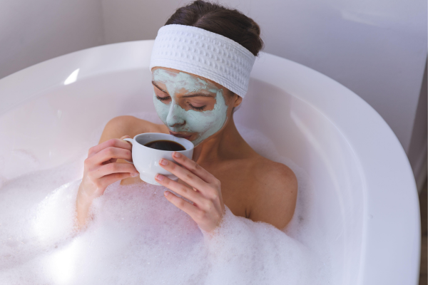 Taking time for yourself is important, as this woman shows relaxing in a bath with hot tea and a face mask
