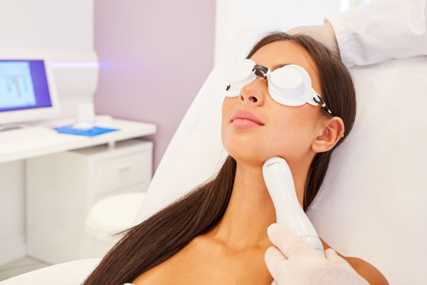 Woman receiving neck tightening treatment with laser device Sourced from: https://www.canva.com/design/DAHO0pkVmeY/7y0zgnieV6uh_bLbW7d5kQ/edit?ui=e30#