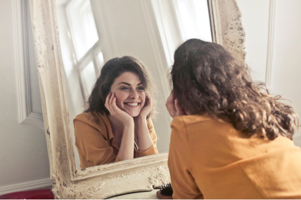 Woman happily looking in the mirror